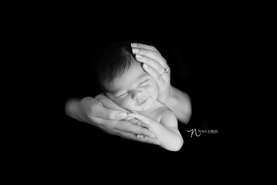 newborn baby posed in moms hands chicago