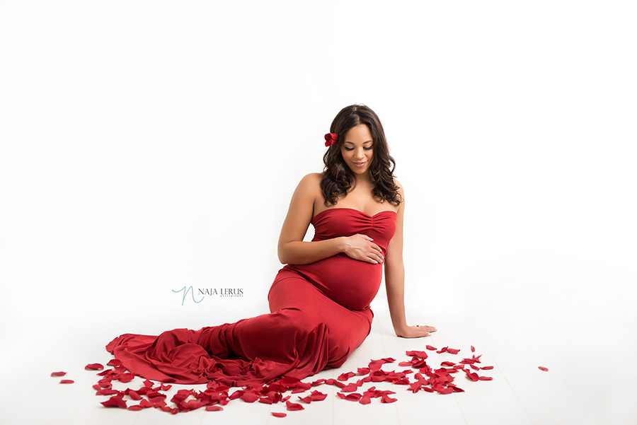 red rose petals maternity photo with red pregnancy dress chicago il