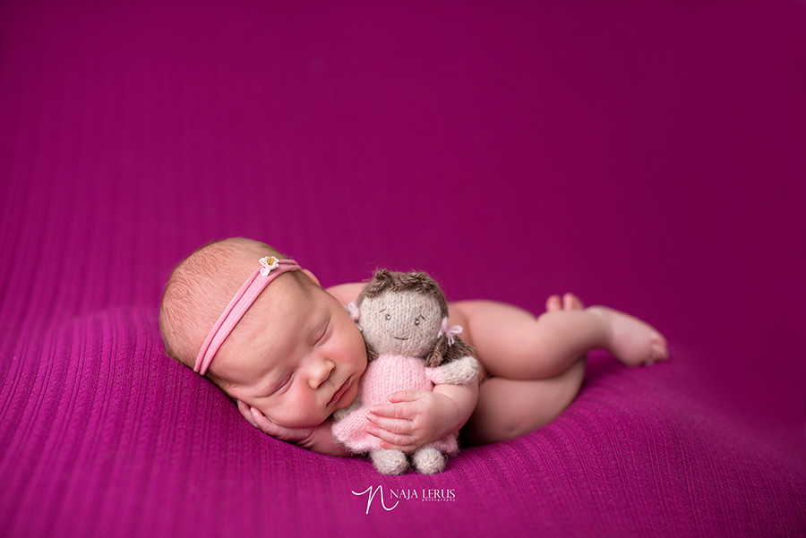 newborn baby girl with stuffed doll prop