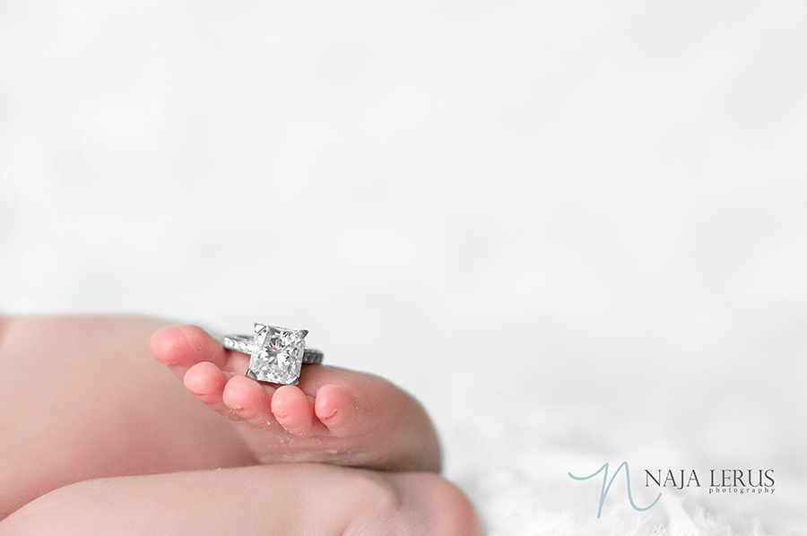 Mom engagement ring posed with newborn baby girl