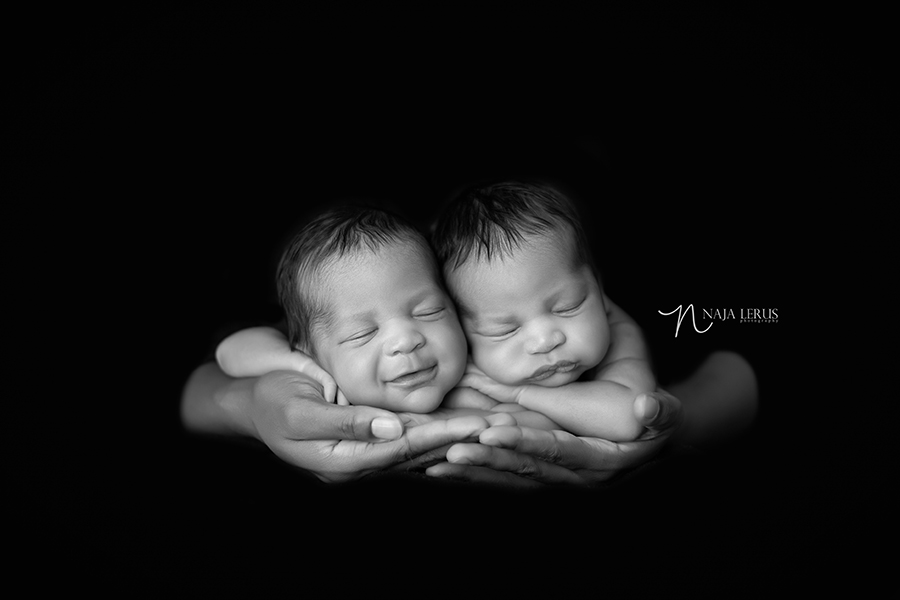 twins in mom's hands black and white