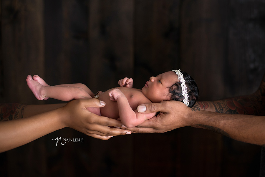 newborn baby in parents hands inspired by derrick rose picture with his son