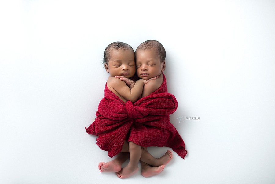 christmas gift newborn twin babies wrapped in red scarf
